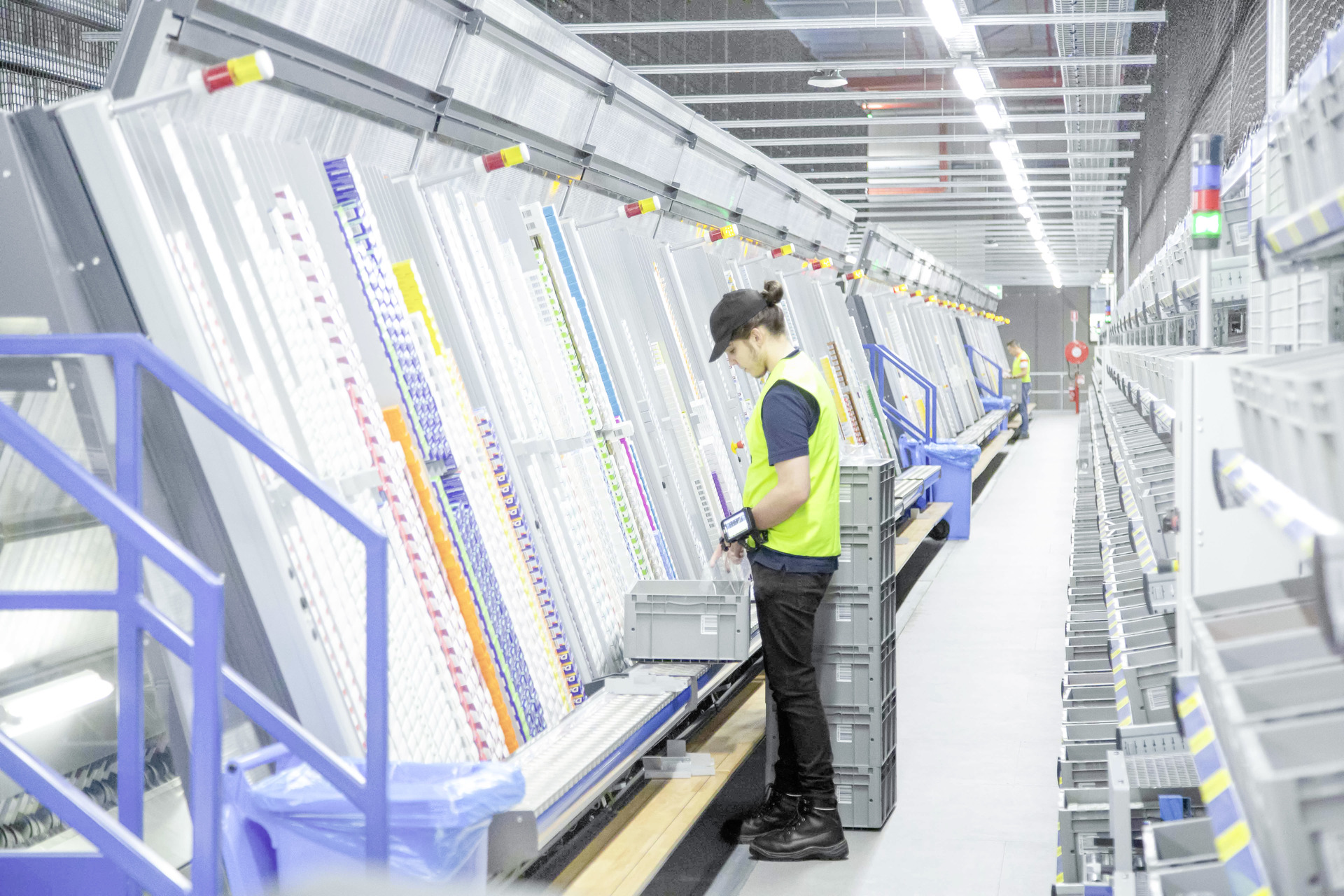 Warehouse worker filling A-frame equipment with stock from stock totes